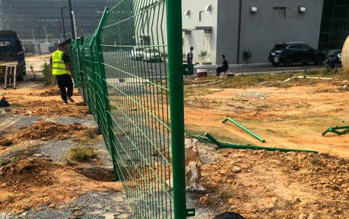 Green PVC Coated Wire Mesh Fence Installation Completed at Industrial Construction Site